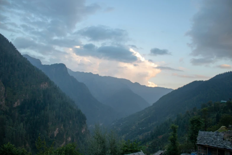 the view from a hill top is shown with mountains in the background