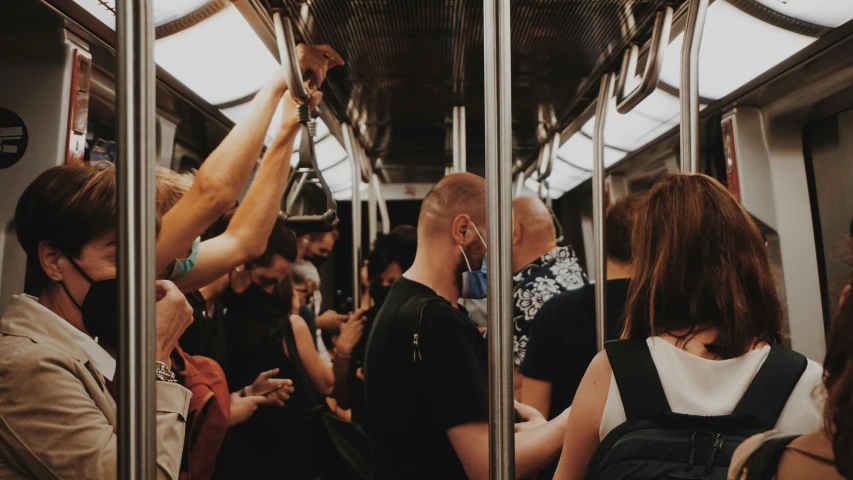 people standing on the subway cars while one is pointing