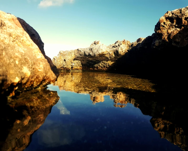 a large rock sitting on top of a body of water