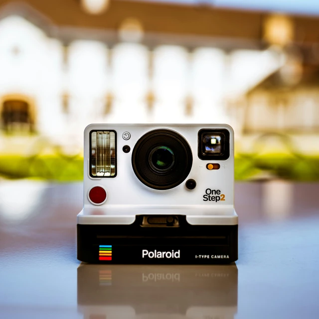 the polaroid camera is next to a building