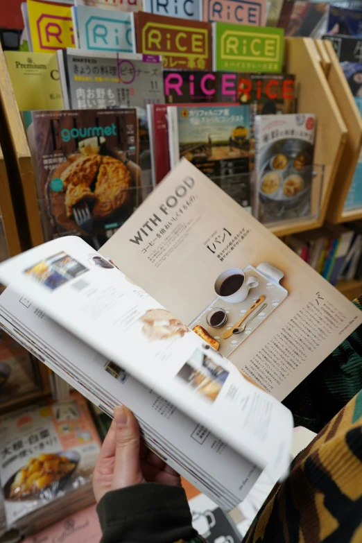 a person is holding up a recipe book