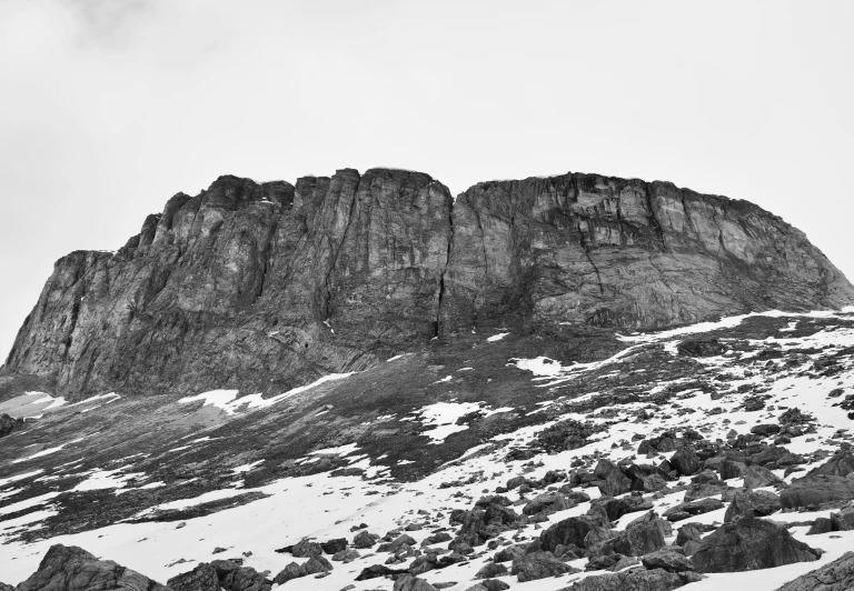 a mountain side covered with snow and mountains in the background