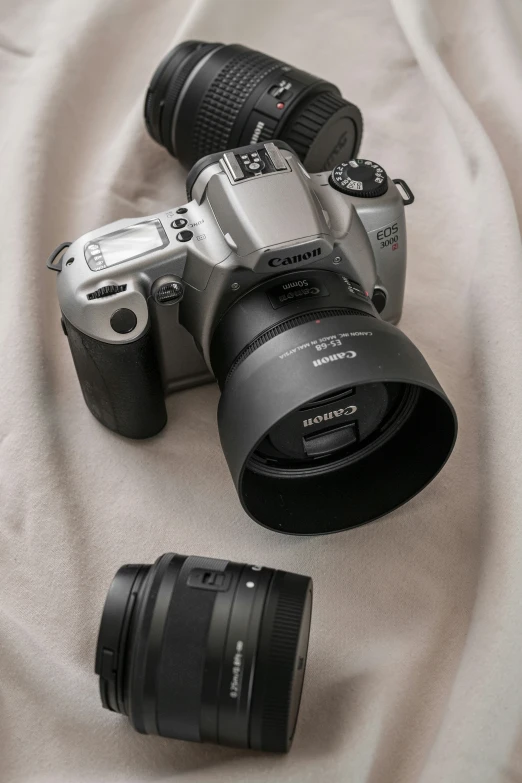 a set of three camera on a white cloth