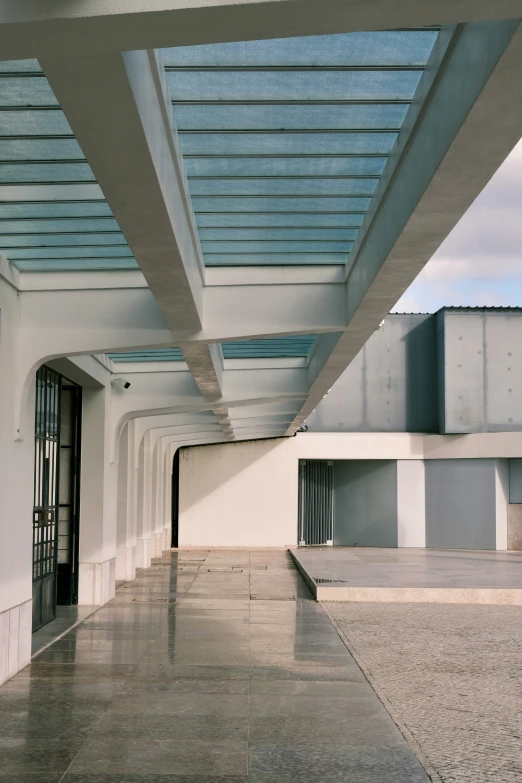 large open area with white walls and tiles with skylights