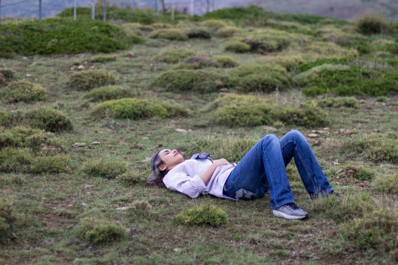 a woman laying in the grass sleeping