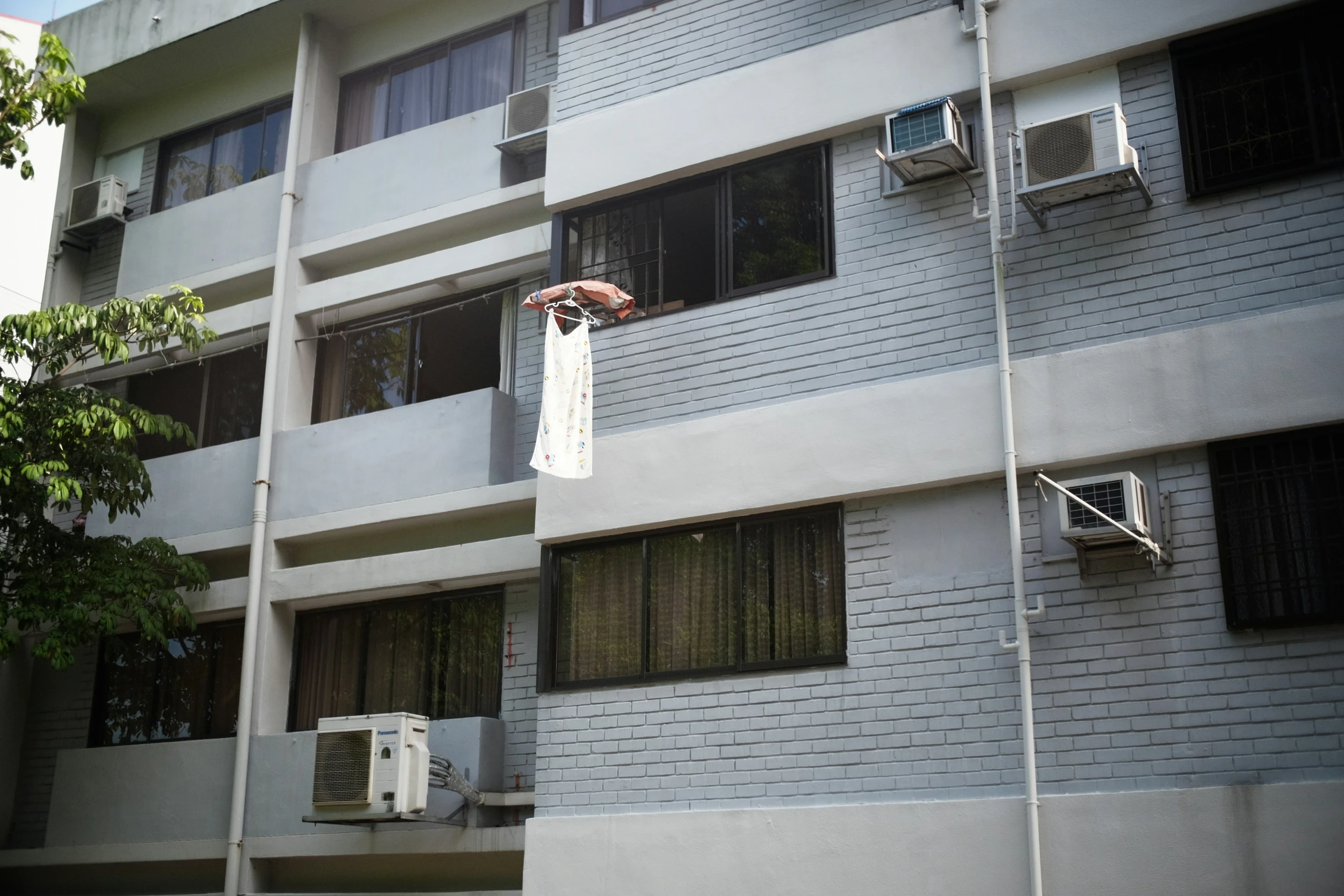 an air conditioner sitting on the side of a gray building