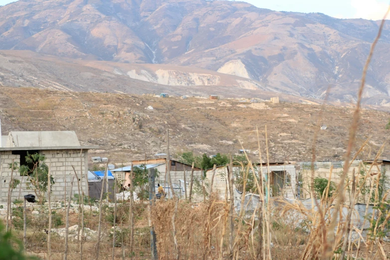 old buildings on a hilly area with mountains in the background