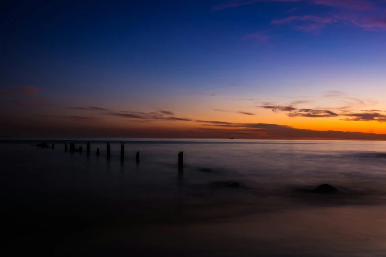 the sun is setting at the ocean with fog coming off