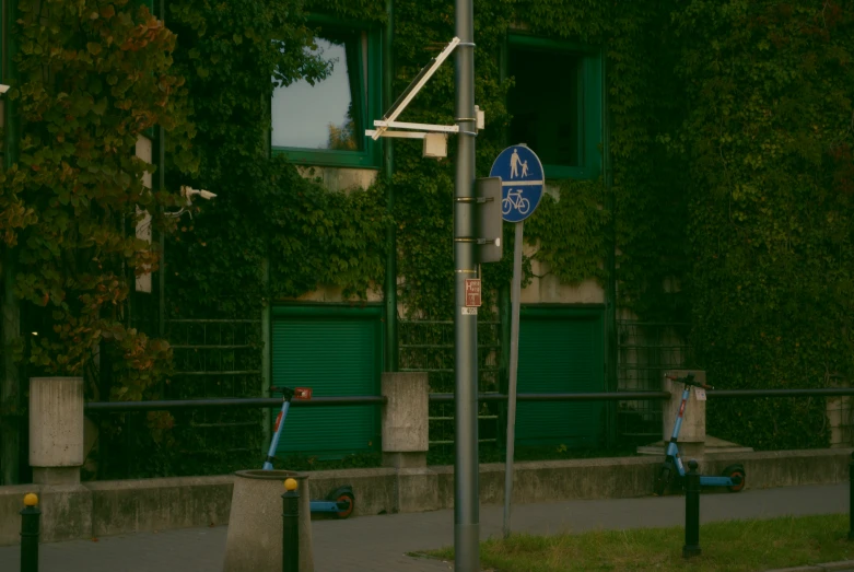 a street sign hanging from the side of a green building