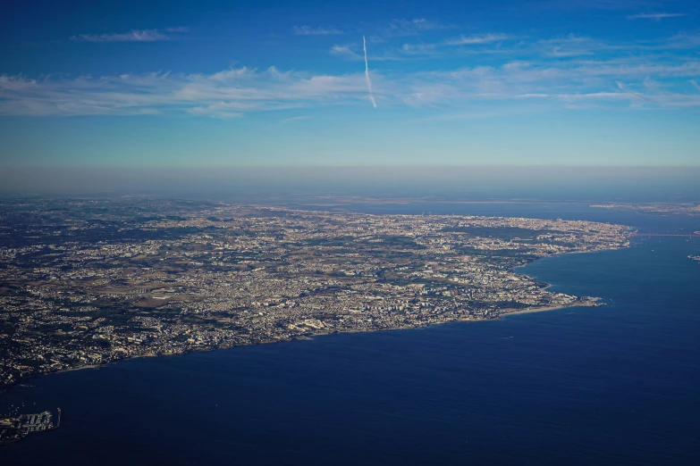 a plane is flying in a clear sky above the city