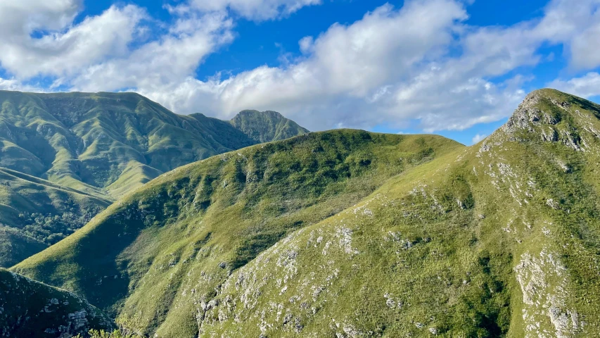 the view from below shows green, grassy and ridged mountains