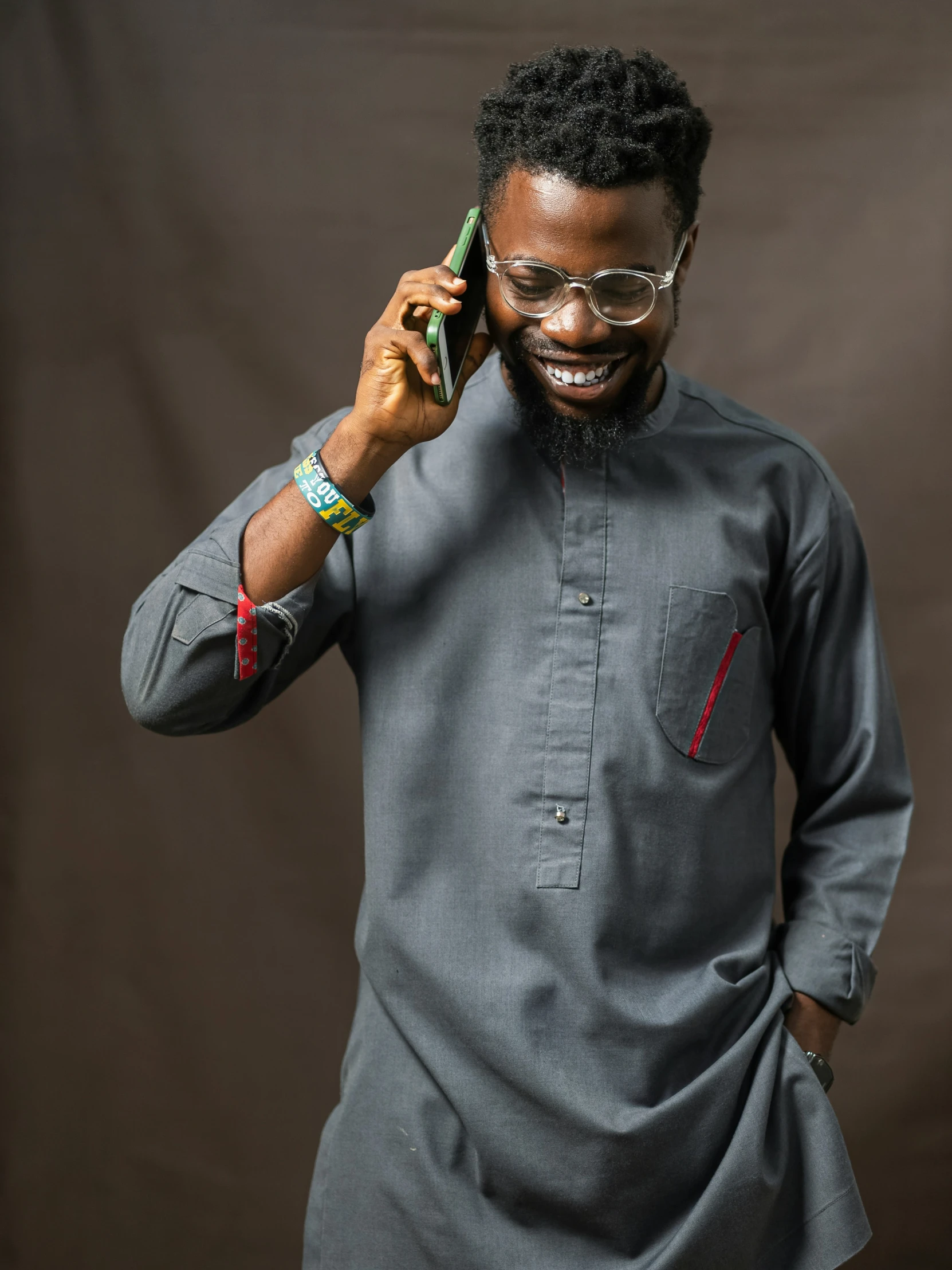 a smiling man wearing glasses and gray clothes