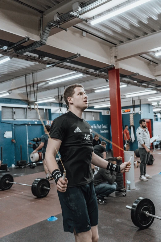 people in a gym with one man holding soing