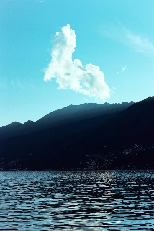 a body of water surrounded by mountains on a clear day