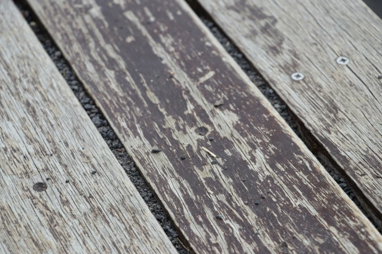 the wooden bench is broken and stained to brown