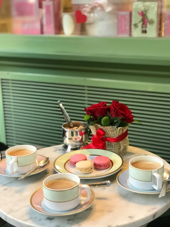 a white table topped with two cups filled with coffee