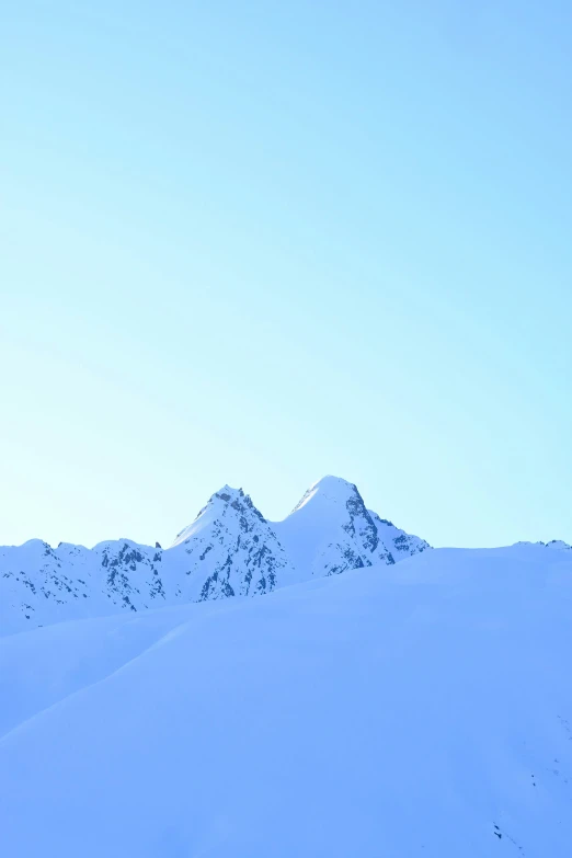 there are two skiers standing near the top of a mountain