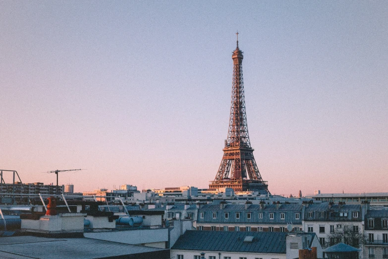 the eiffel tower at sunrise is shown from a roof