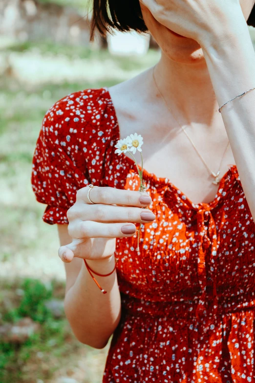 an individual with some type of finger ring and flower in hand