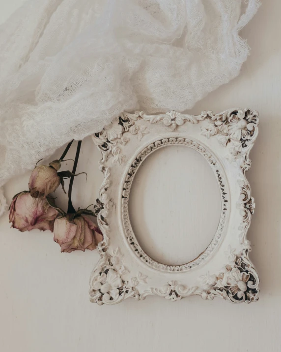 a white frame with roses and a lace