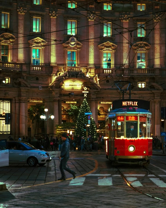 an image of a red trolley on street at night