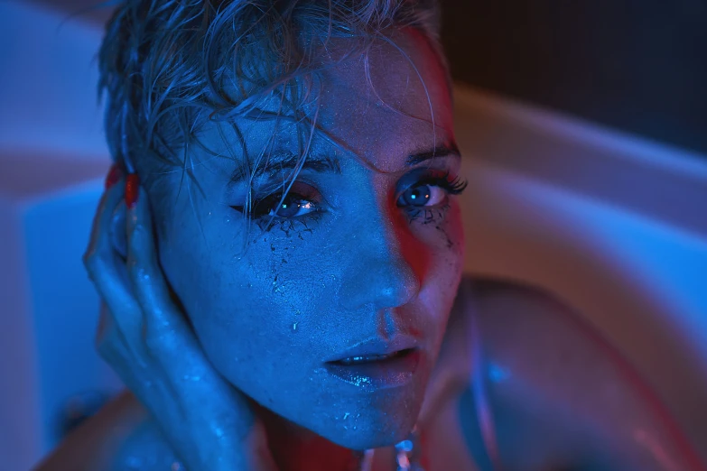 the woman is bathed in a bathtub with blue lights