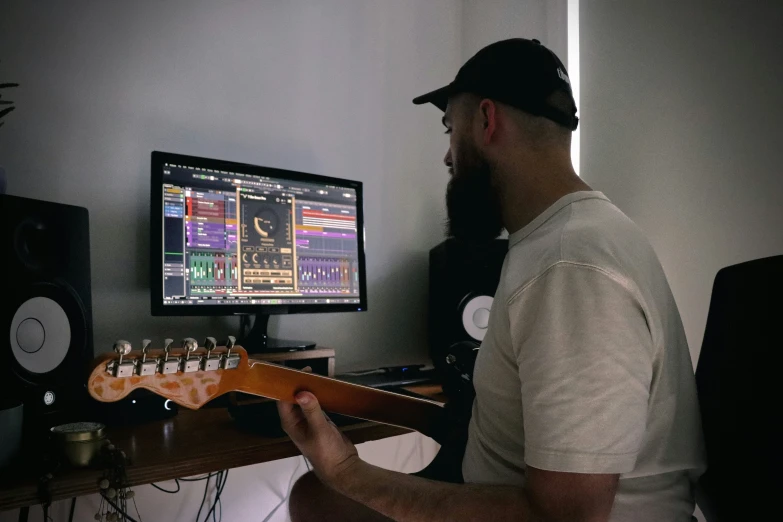 man playing guitar in front of a tv