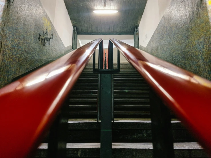 a red rail running down stairs inside of a building