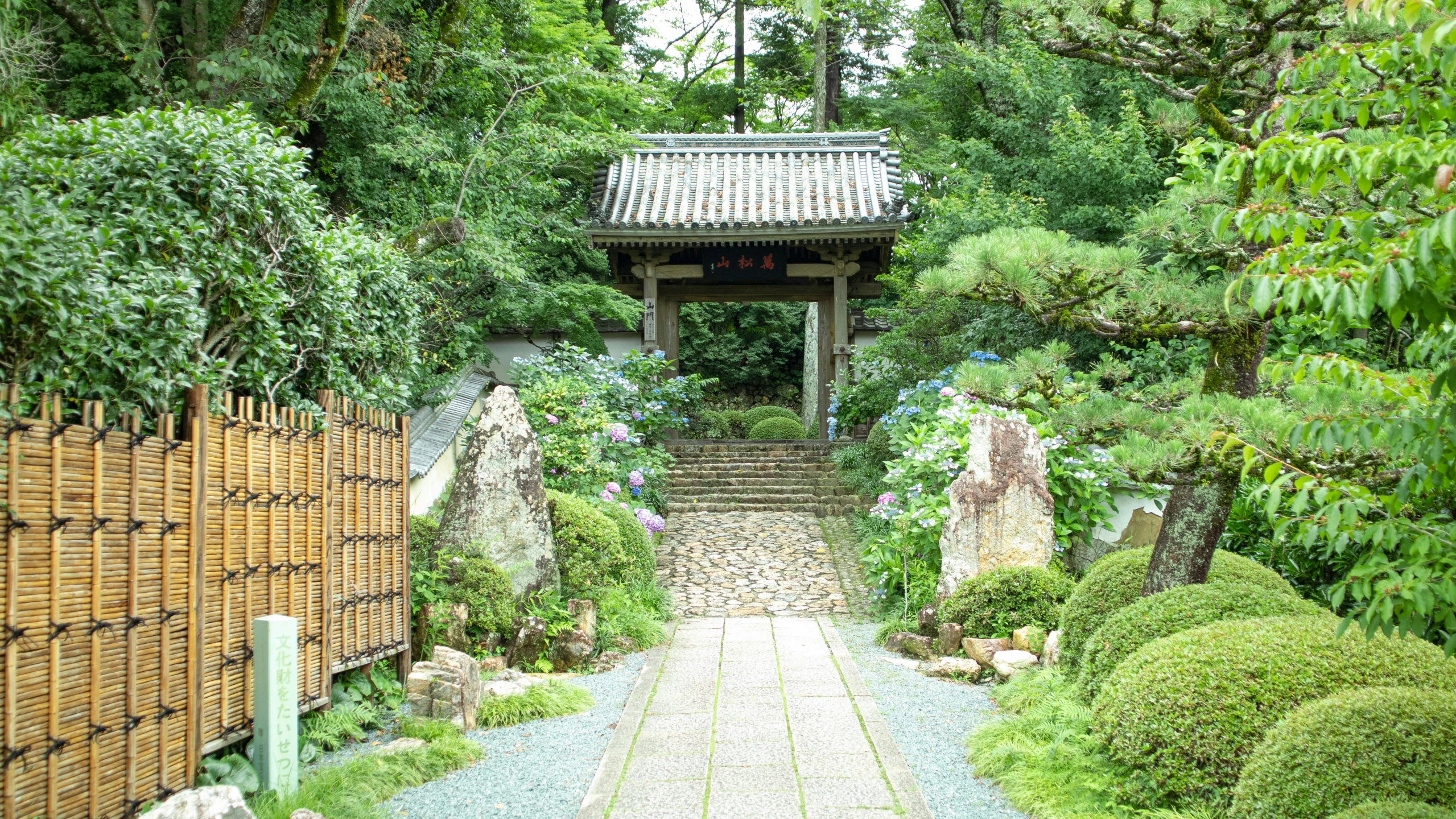 this is a view of a gated area with rocks and grass