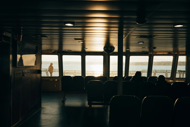 people standing in front of large windows looking out at the water