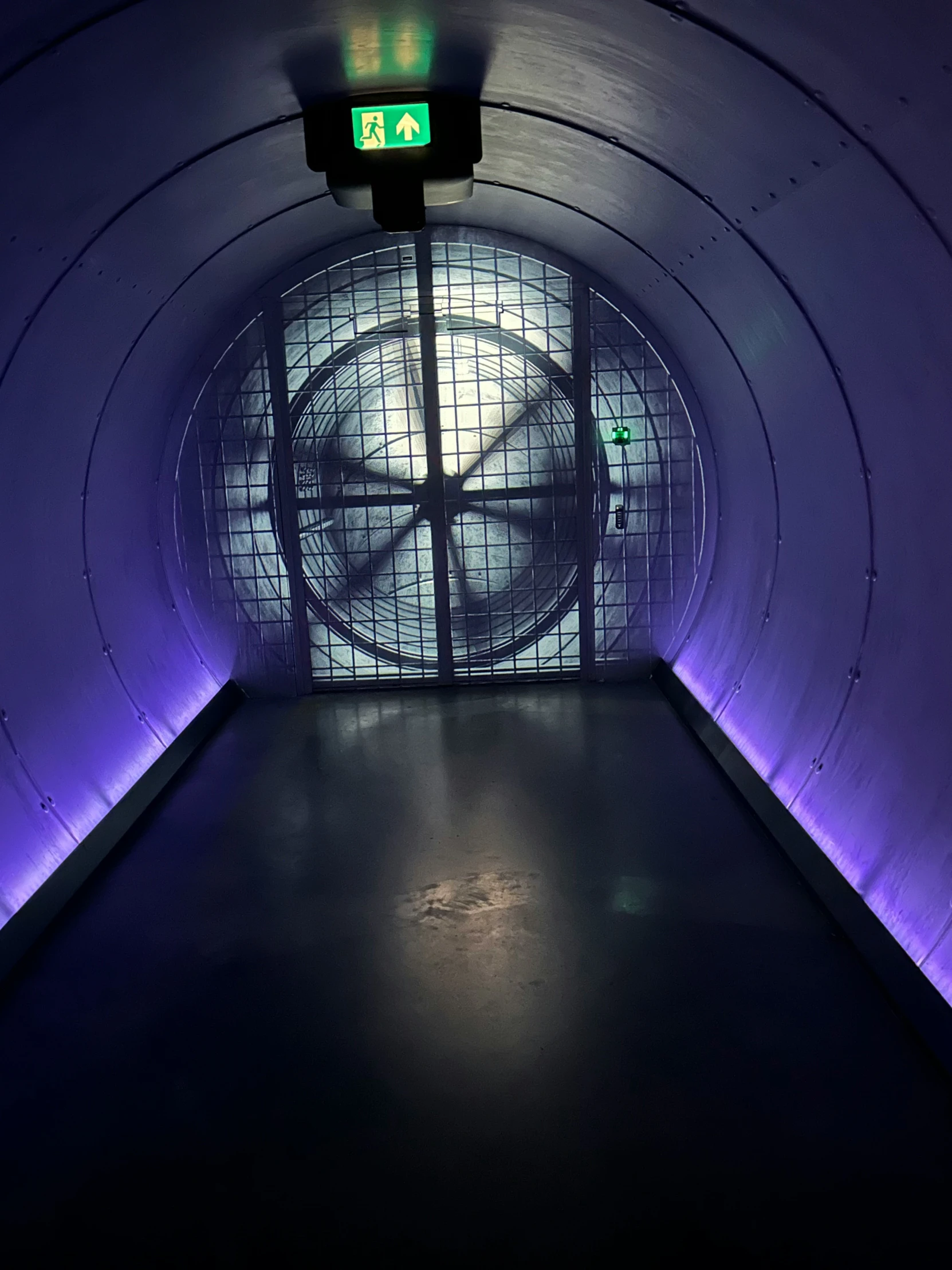 a subway tunnel with a clock inside and purple lighting