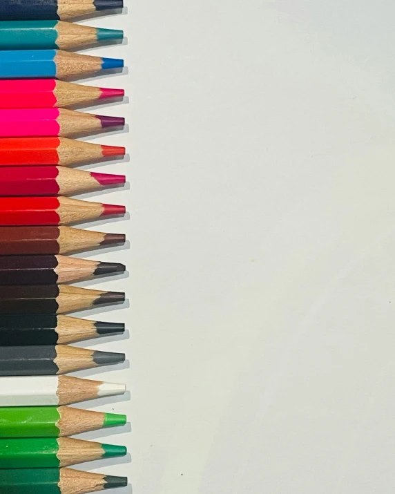 several different colored pencils lined up in a single row