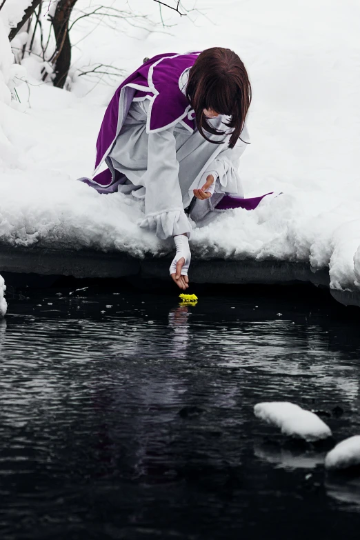 a  kneeling on the snow looking at a ball