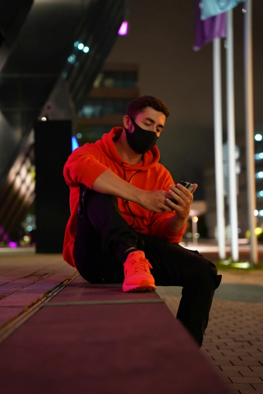 man sitting on floor using his phone at night