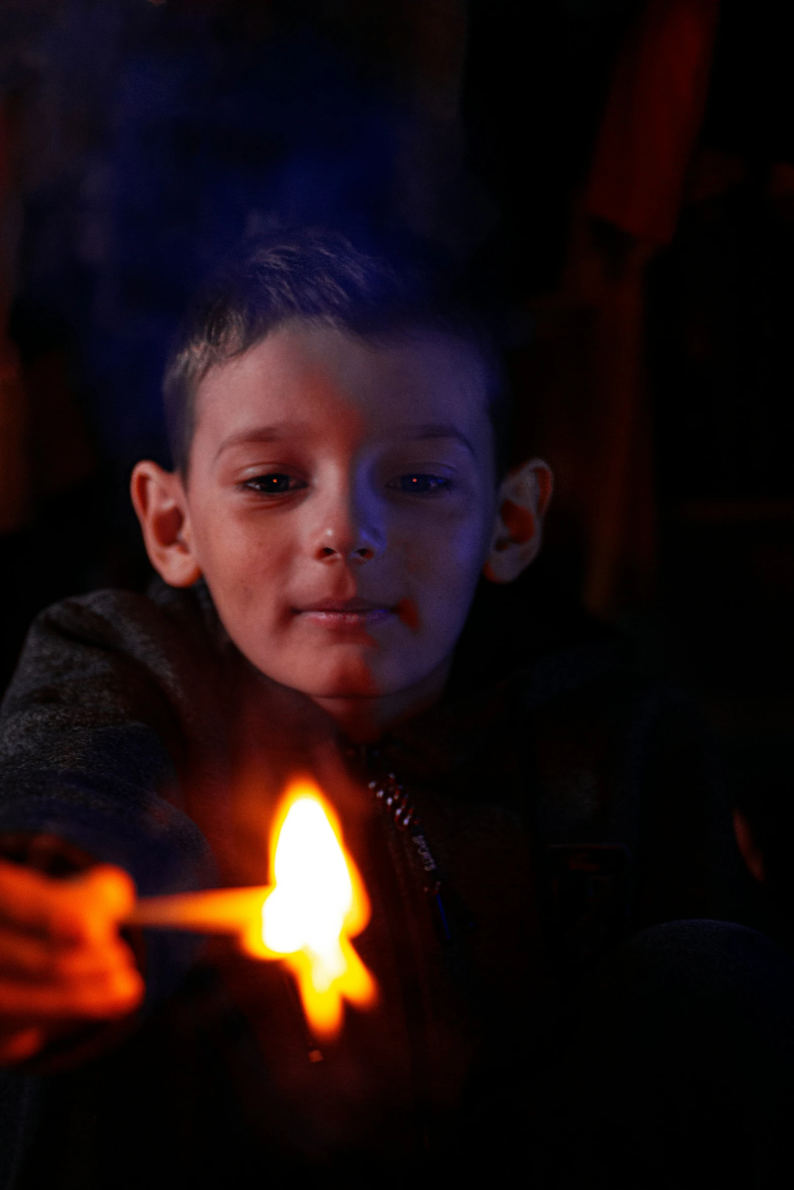 a boy holding a lit candle in his right hand