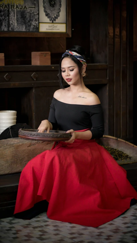 a woman sitting on top of a bed holding a plate