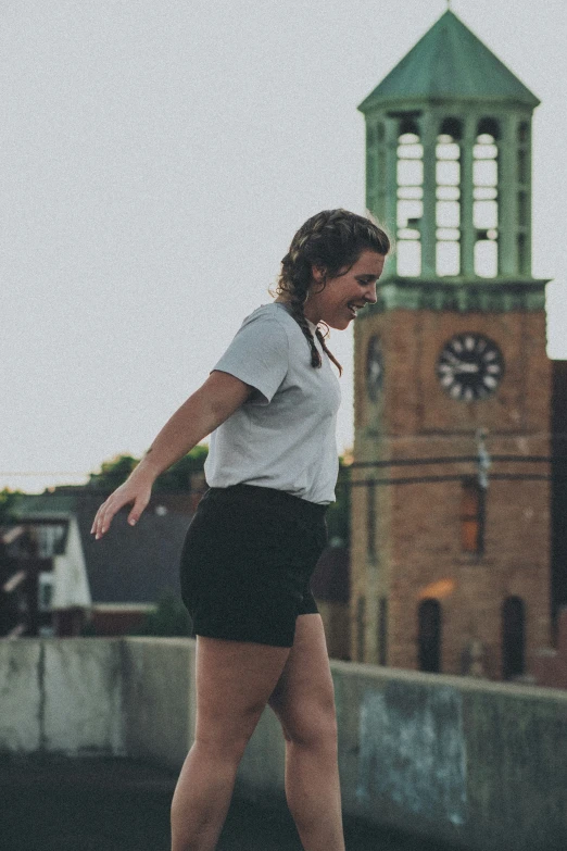 a woman wearing short black skirt and white shirt skate boarding