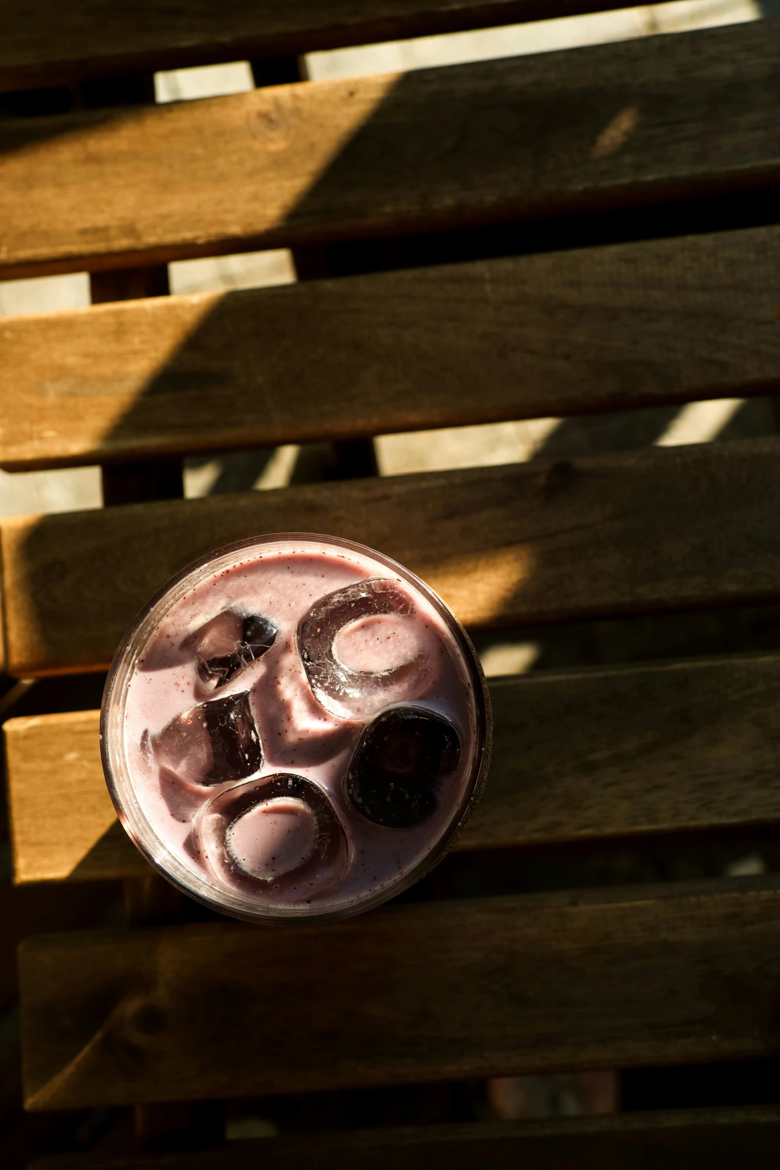 a drink with fruit is sitting on top of a bench