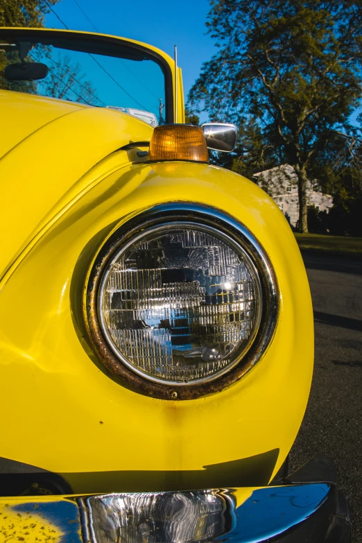 the front light of an old yellow car