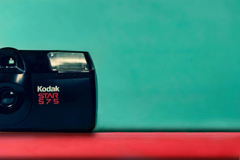 a polaroid camera on a table with a green background