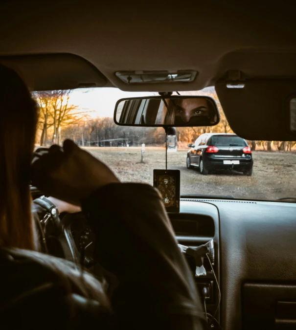 there is a man driving his car next to the woman