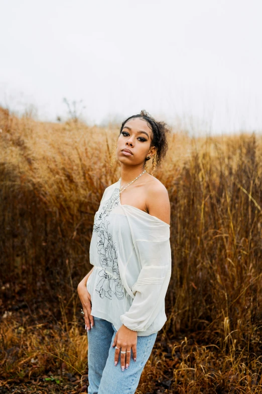 an african american woman wearing jeans and a white top