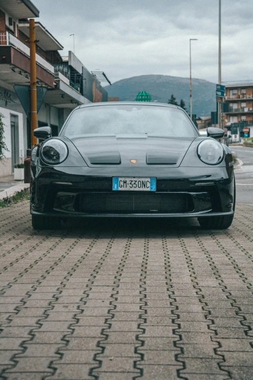 a porsche gt3 on a brick driveway