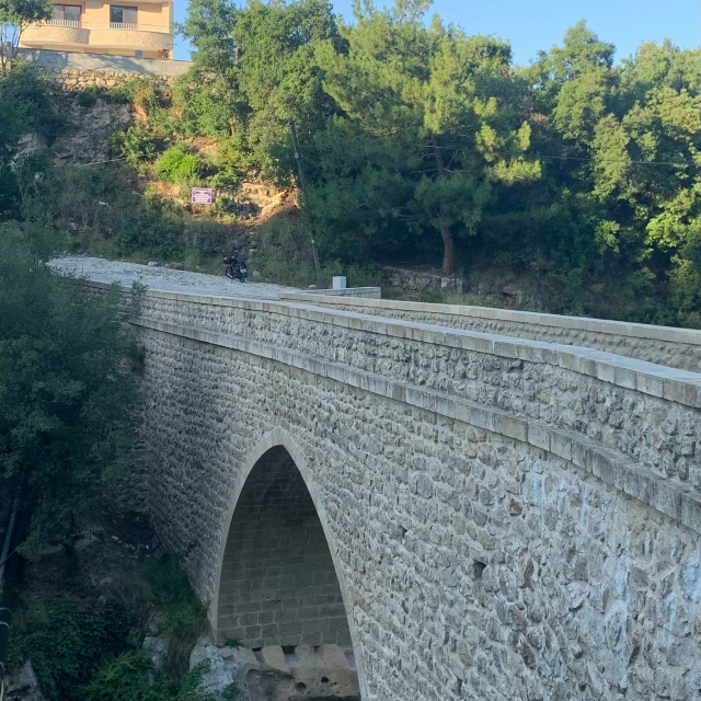 people are riding their motorbikes across a bridge