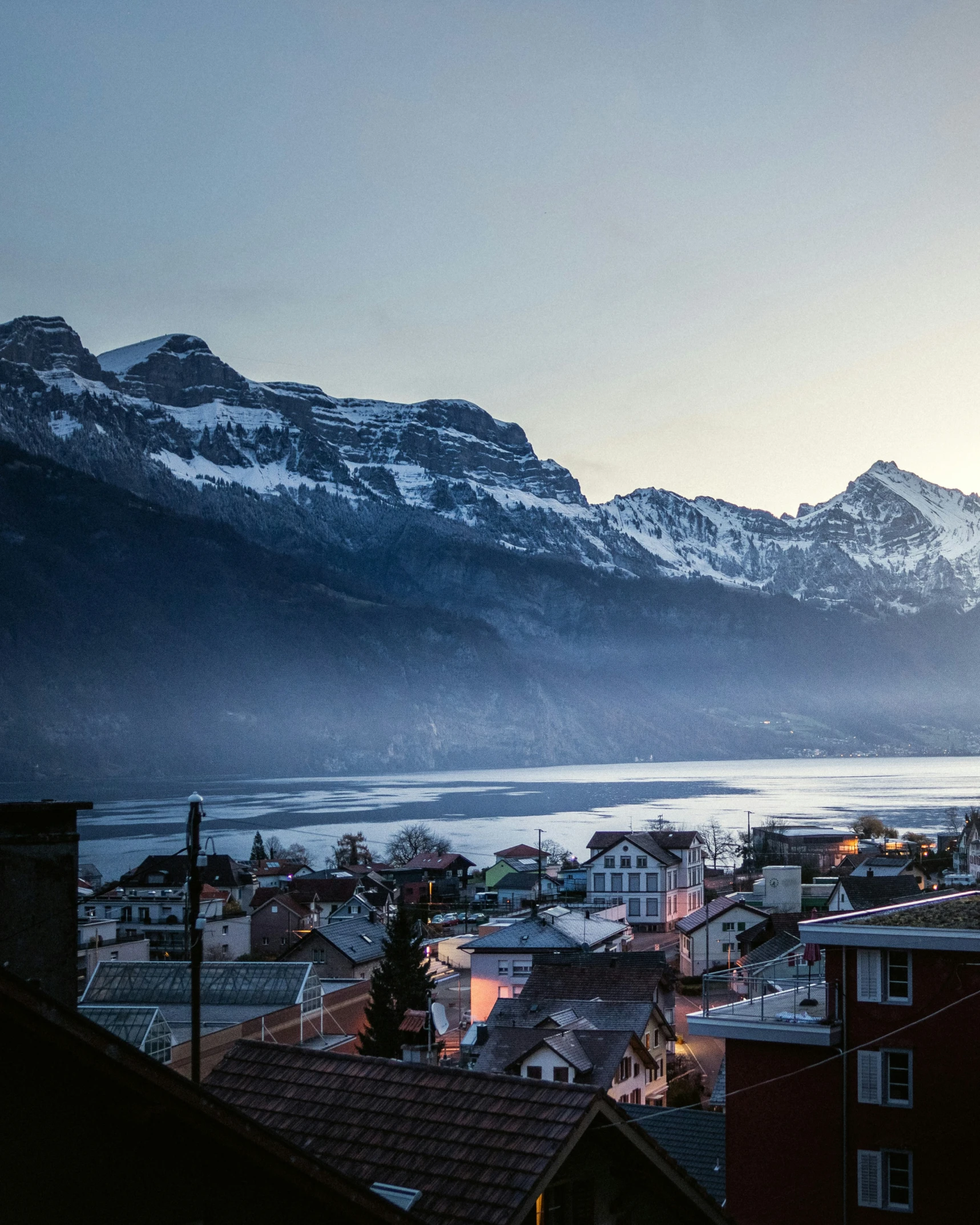 the snow covered mountains are on both sides of the town