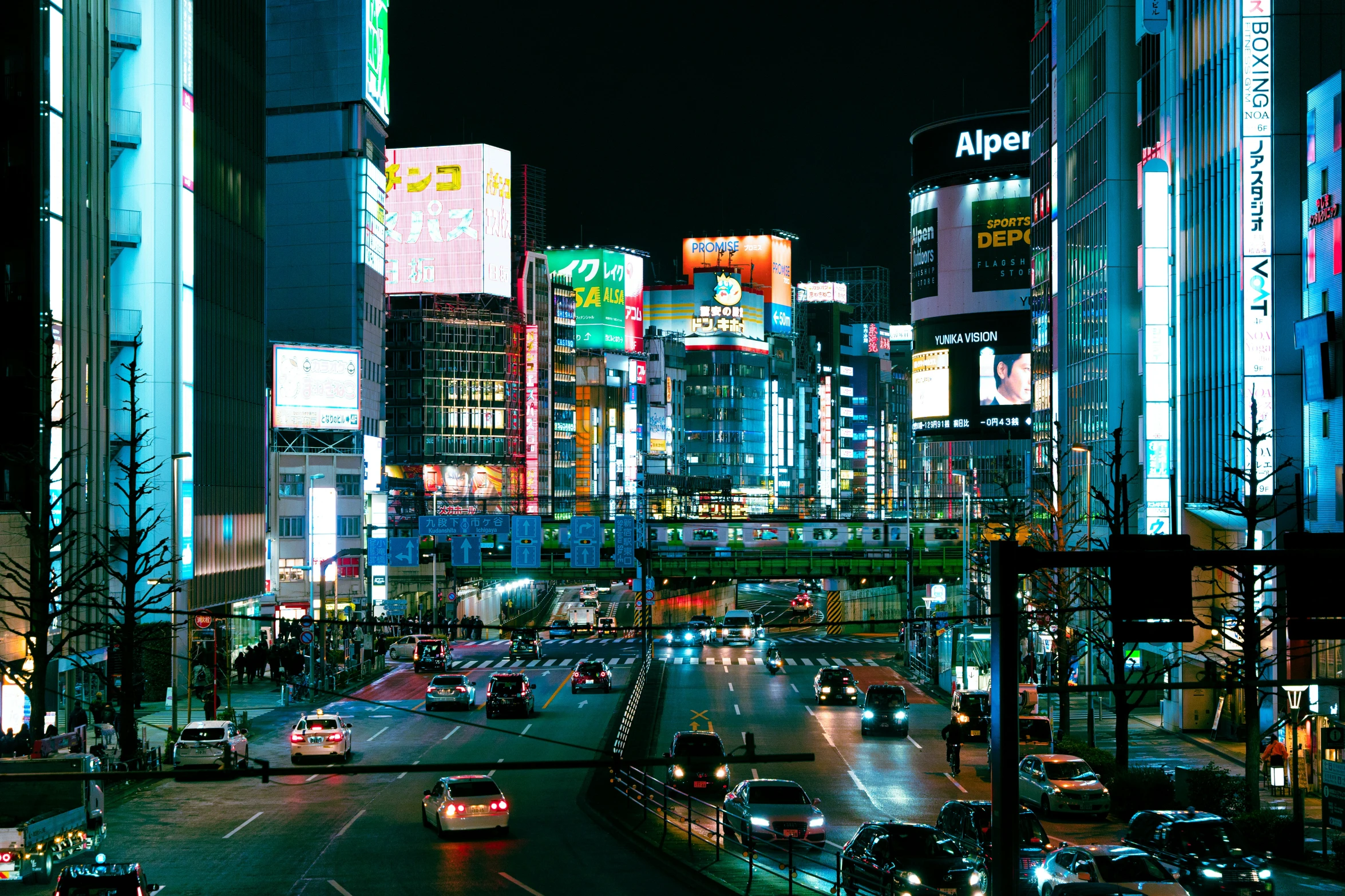 a street full of cars driving down a city road