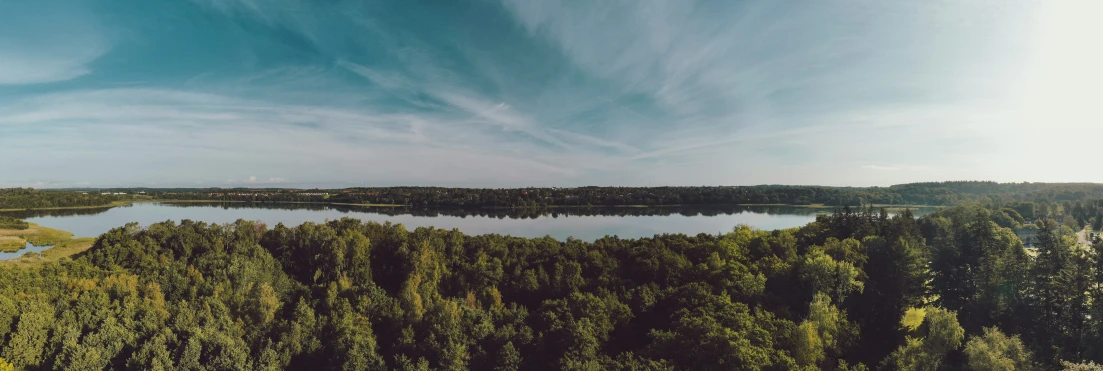 trees surrounding the water under a sky full of clouds