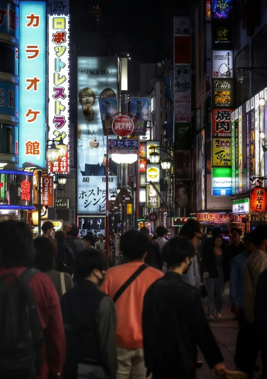 a busy city street with advertits at night