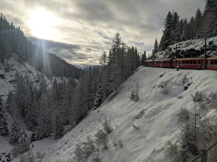 a train is going through a snow covered mountain