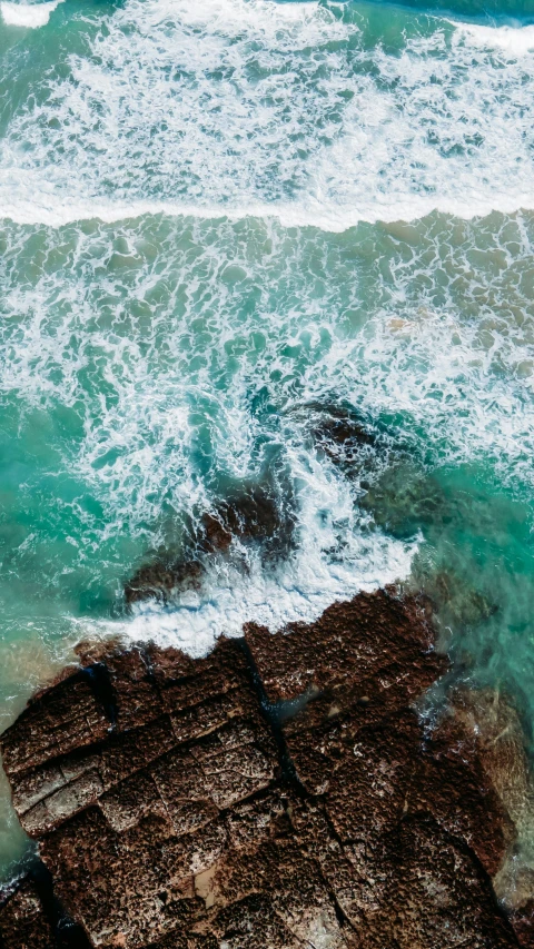 the ocean's water has foamy, green waves